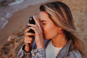 Una donna che tiene un telefono cellulare fino al suo viso