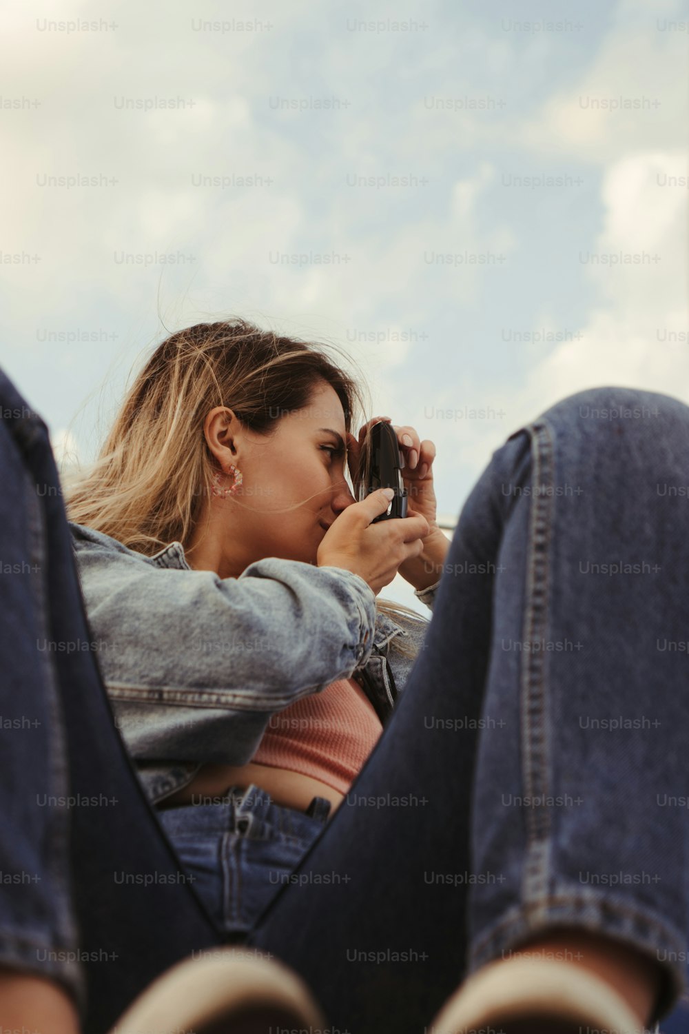 uma mulher sentada no chão olhando para o celular