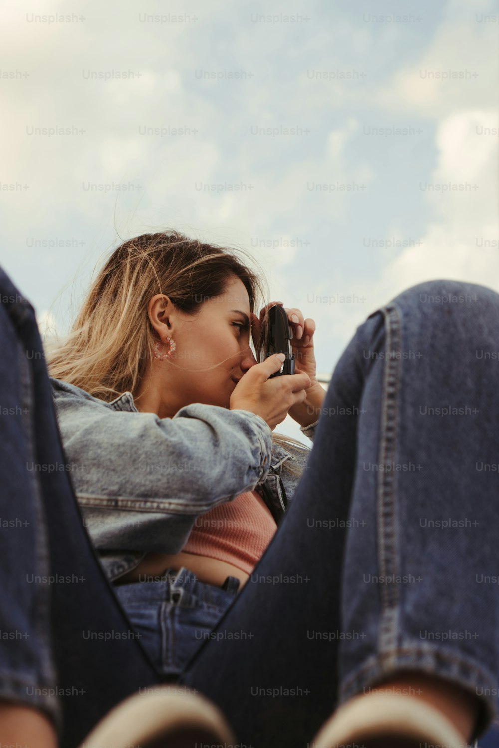 Una donna seduta a terra che guarda il suo cellulare