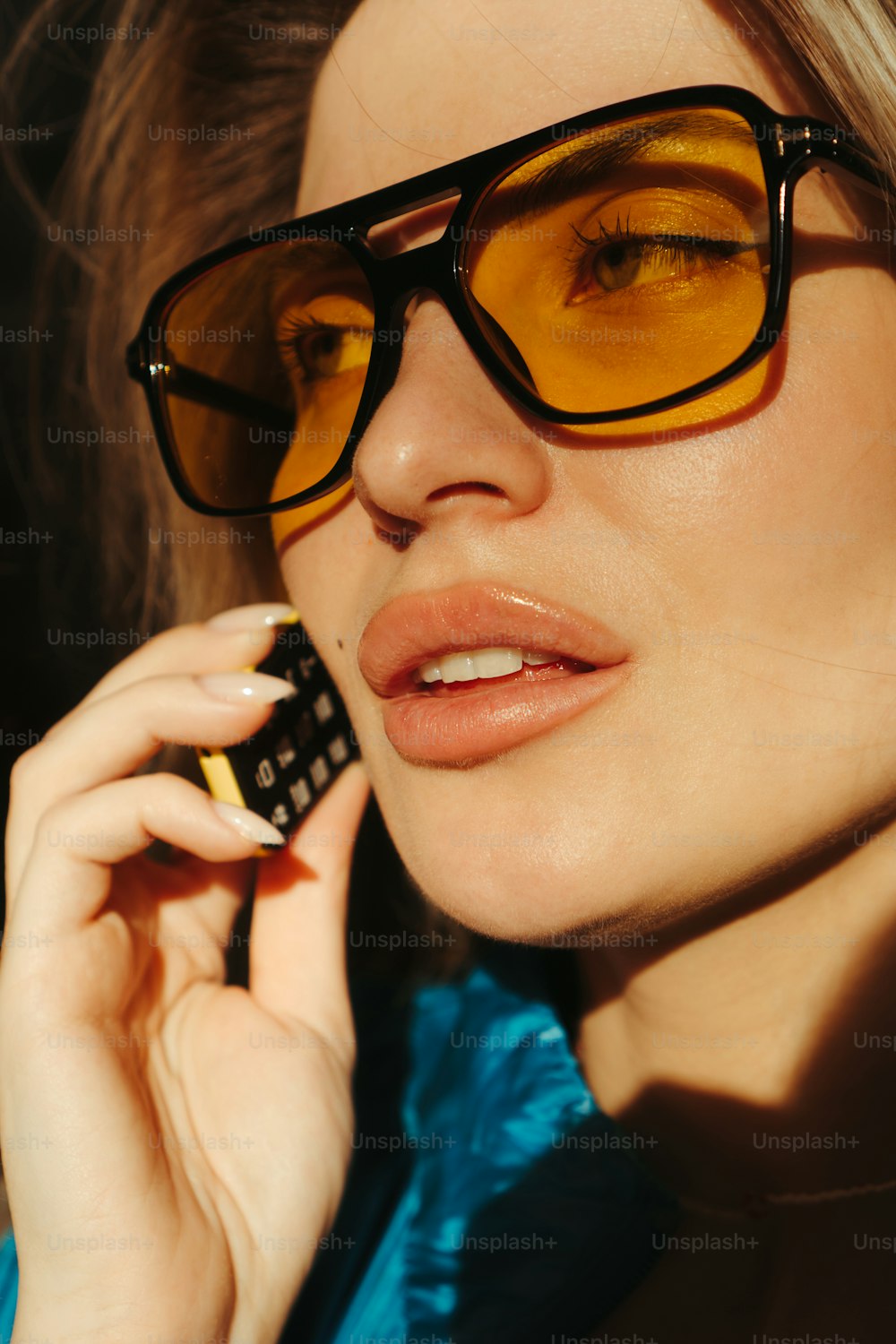 眼鏡をかけた女性が携帯電話で話している