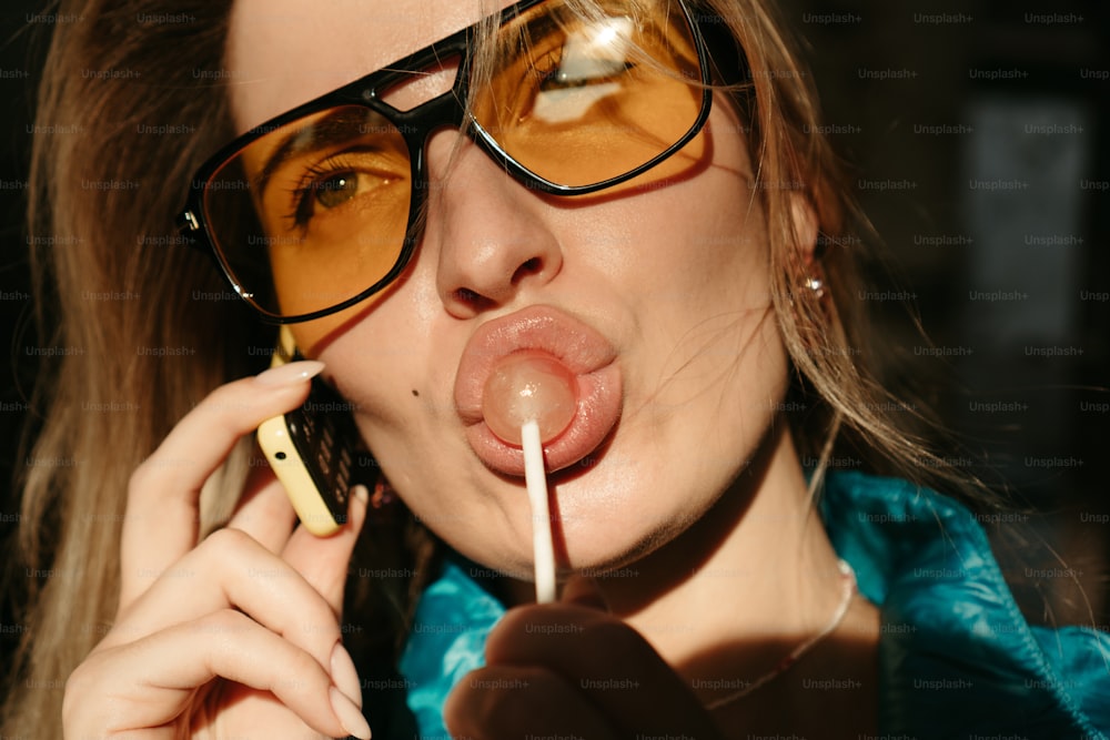 a woman wearing glasses and holding a cigarette in her mouth