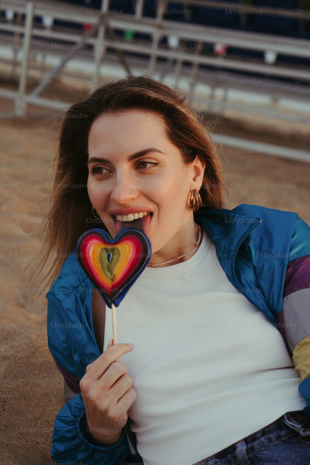 a woman is holding a heart shaped lollipop
