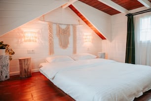 a bedroom with a white bed and wooden floors