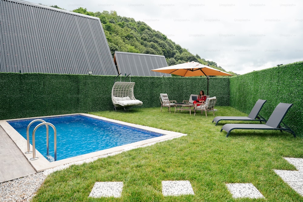 a backyard with a pool and lawn furniture