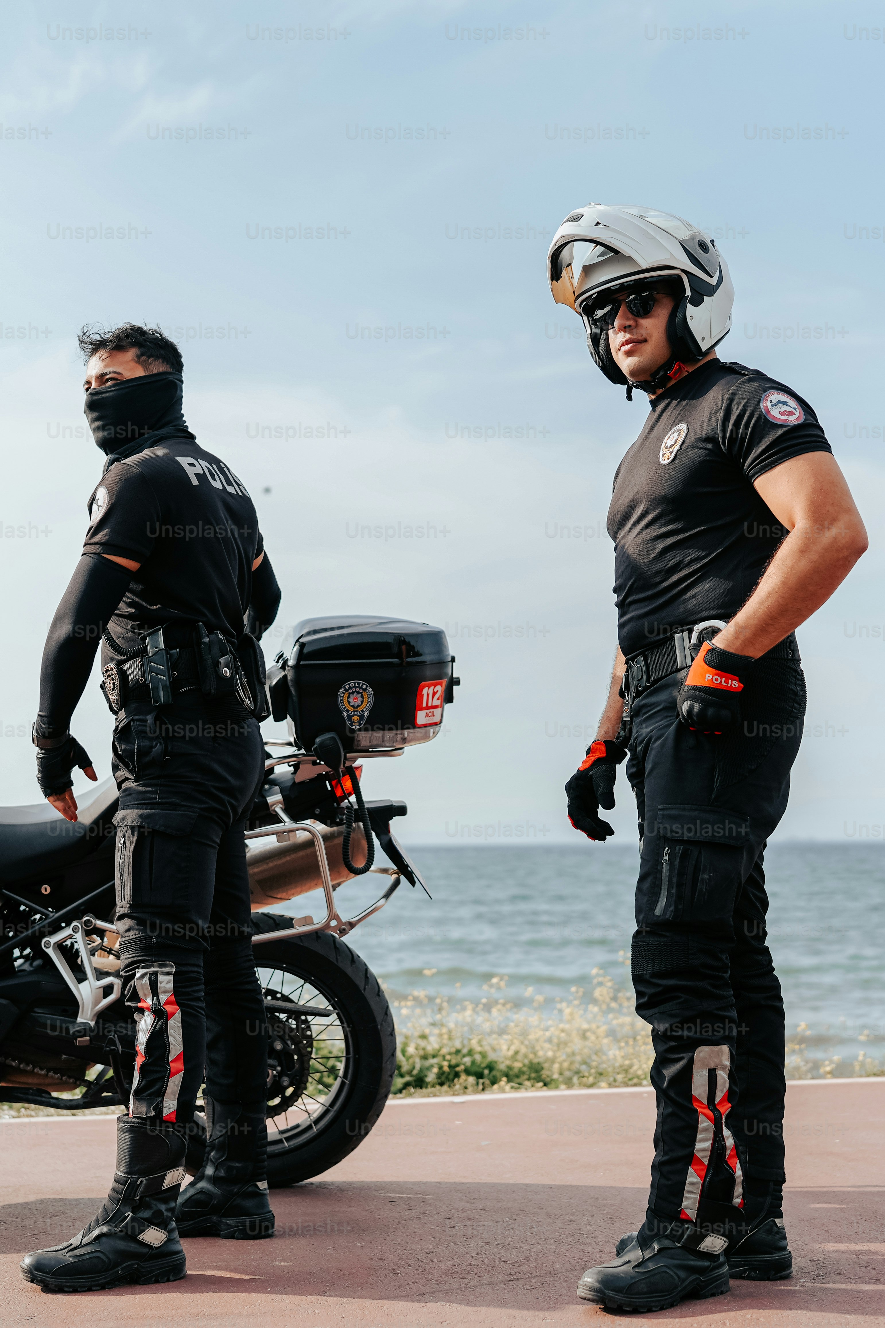 a couple of men standing next to each other near a motorcycle