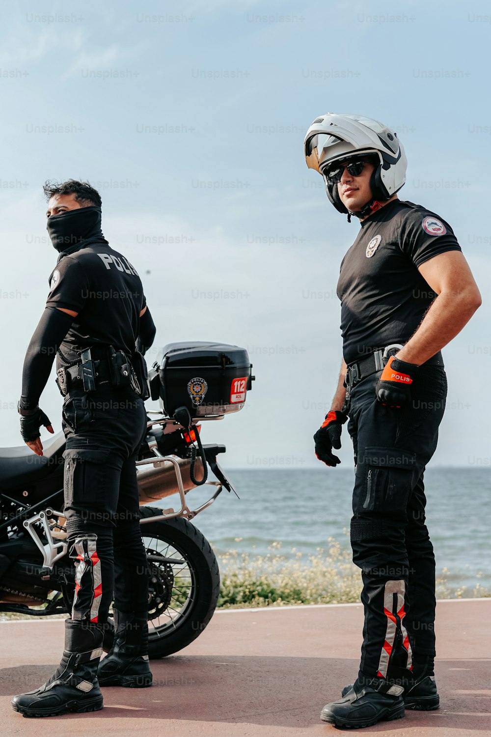 a couple of men standing next to each other near a motorcycle