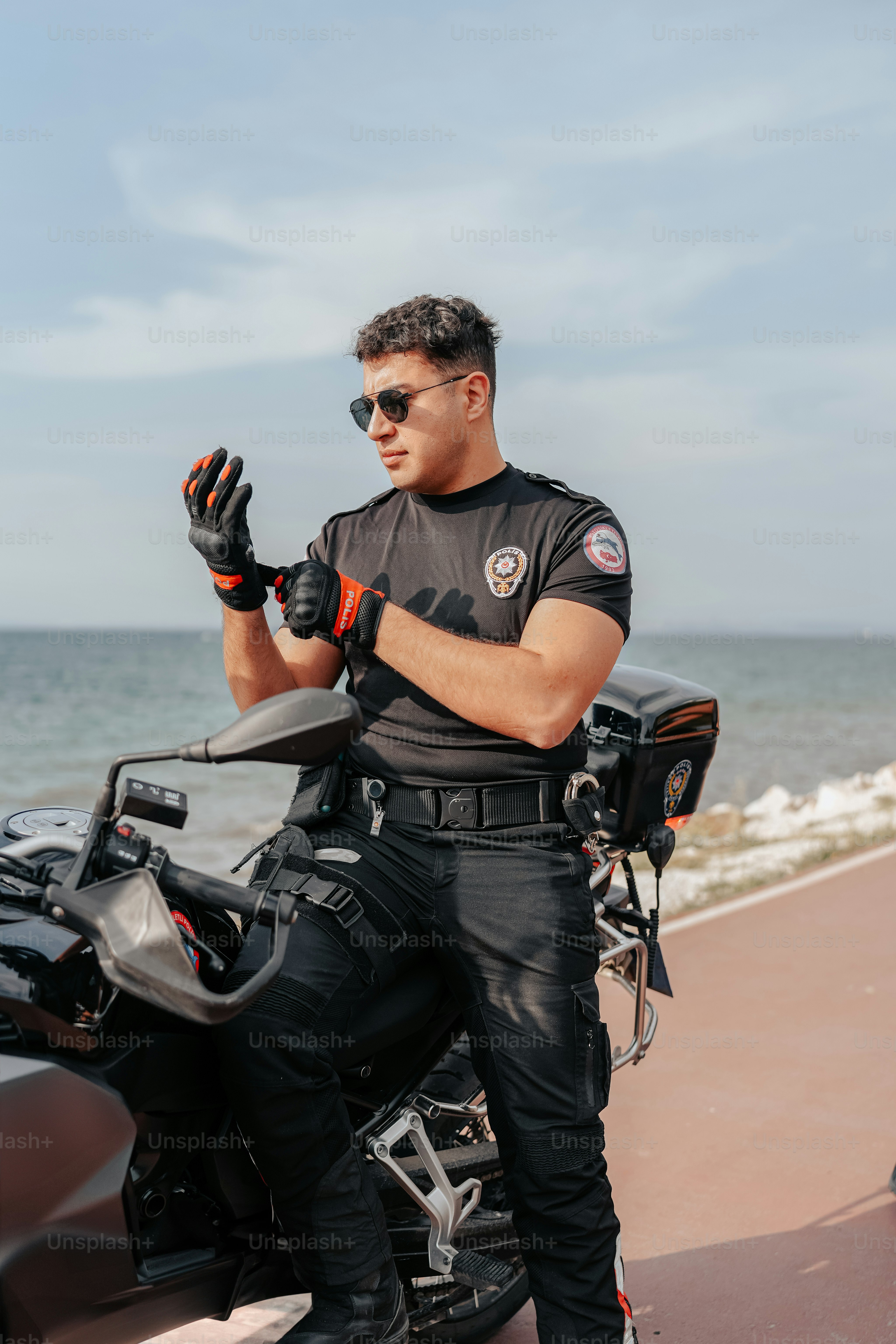 a man standing next to a motorcycle near the ocean