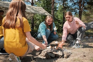 Un groupe de jeunes femmes assises autour d’un feu de camp