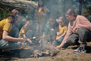 a group of people sitting around a campfire