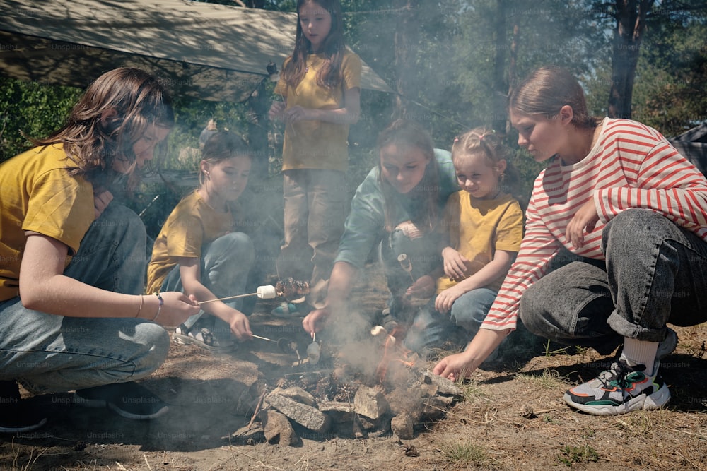 a group of people sitting around a campfire