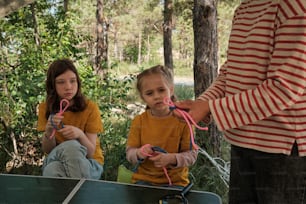 two young girls sitting on the ground with scissors in their hands