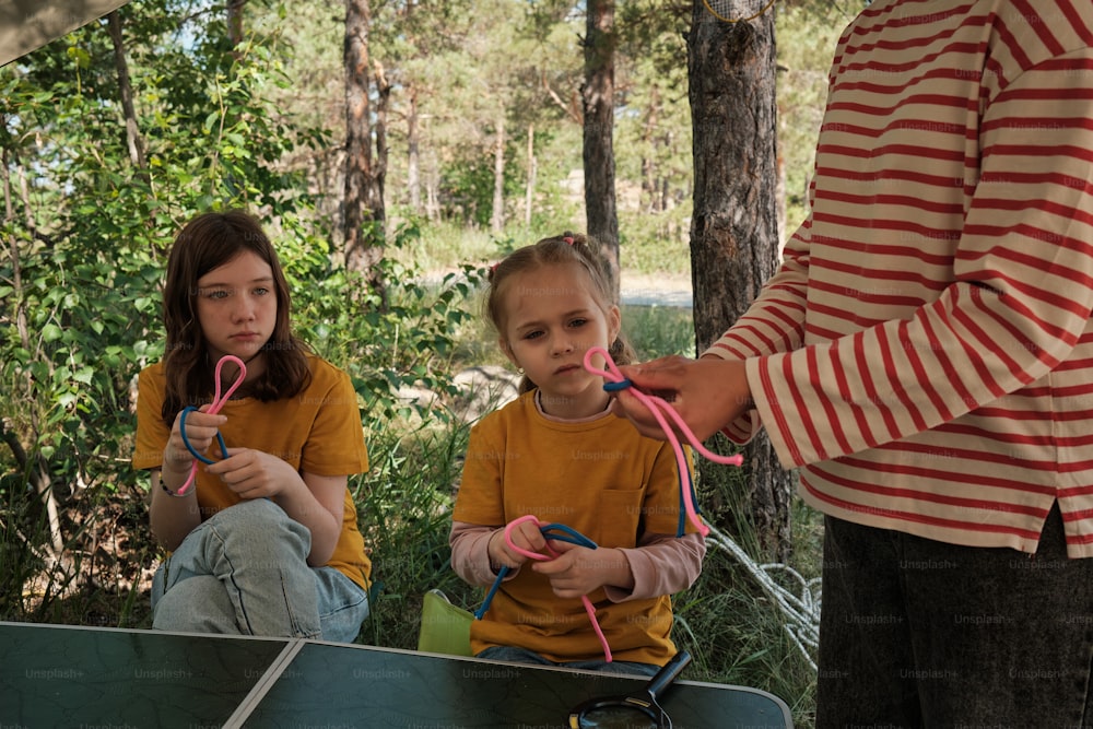 two young girls sitting on the ground with scissors in their hands