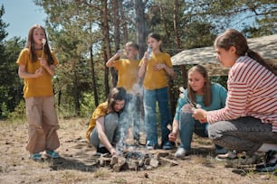 a group of people standing around a campfire