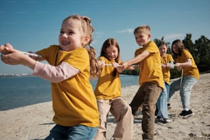 a group of children playing tug of war on the beach