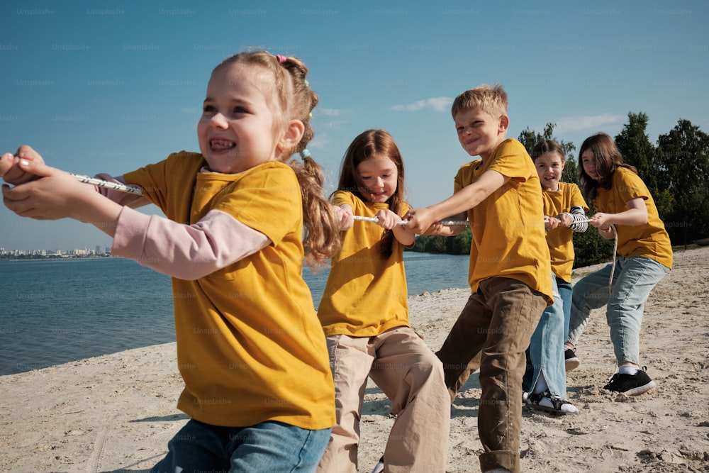 Un grupo de niños jugando al tira y afloja en la playa