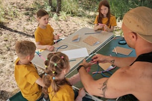 Un grupo de niños sentados en una mesa trabajando en manualidades
