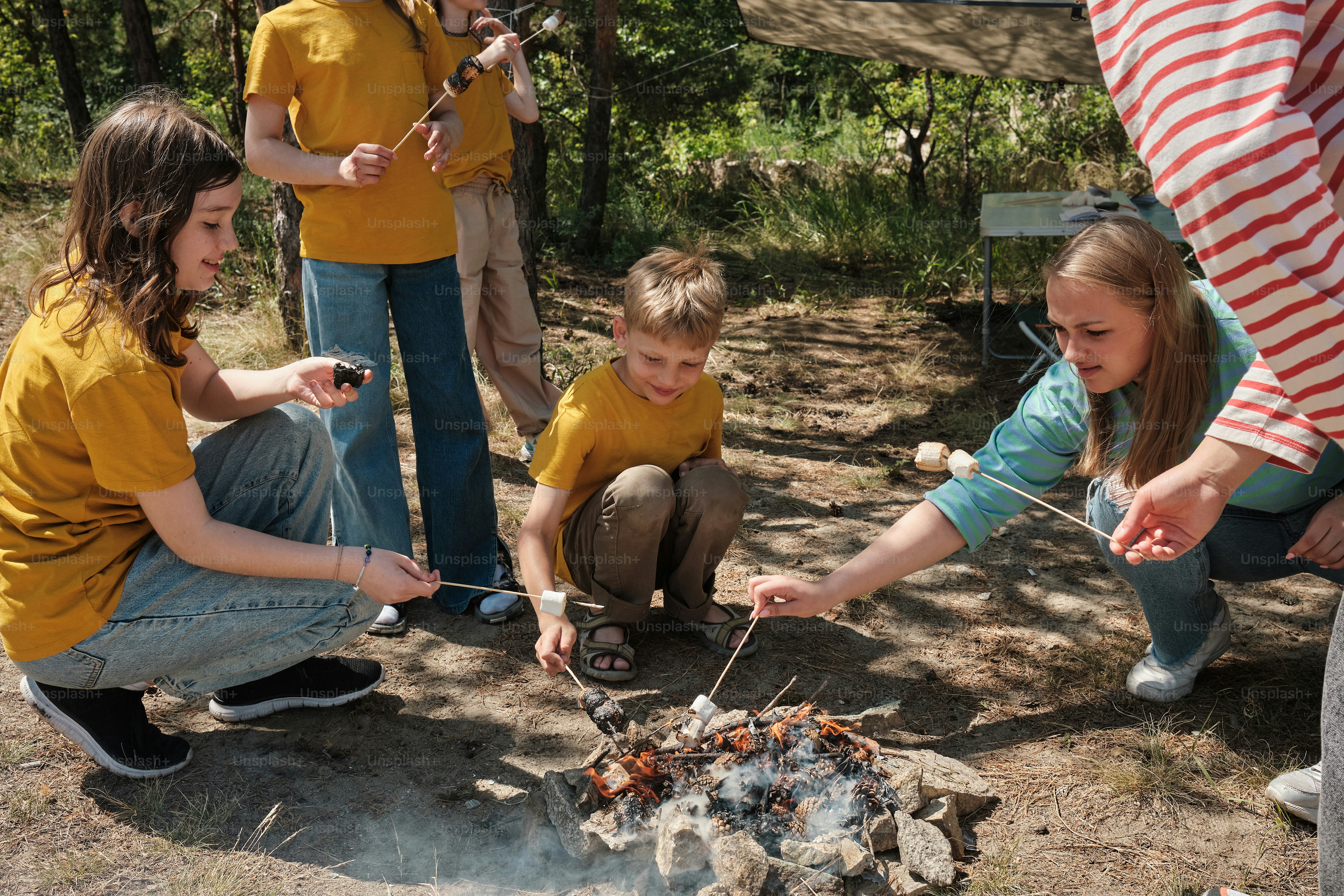 a group of people standing around a campfire