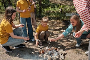 a group of people standing around a campfire