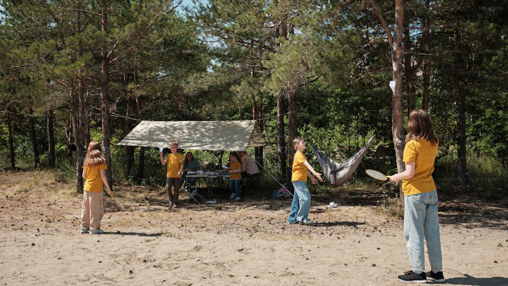 a group of people playing frisbee in the woods