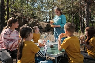 a group of children sitting around a table eating food