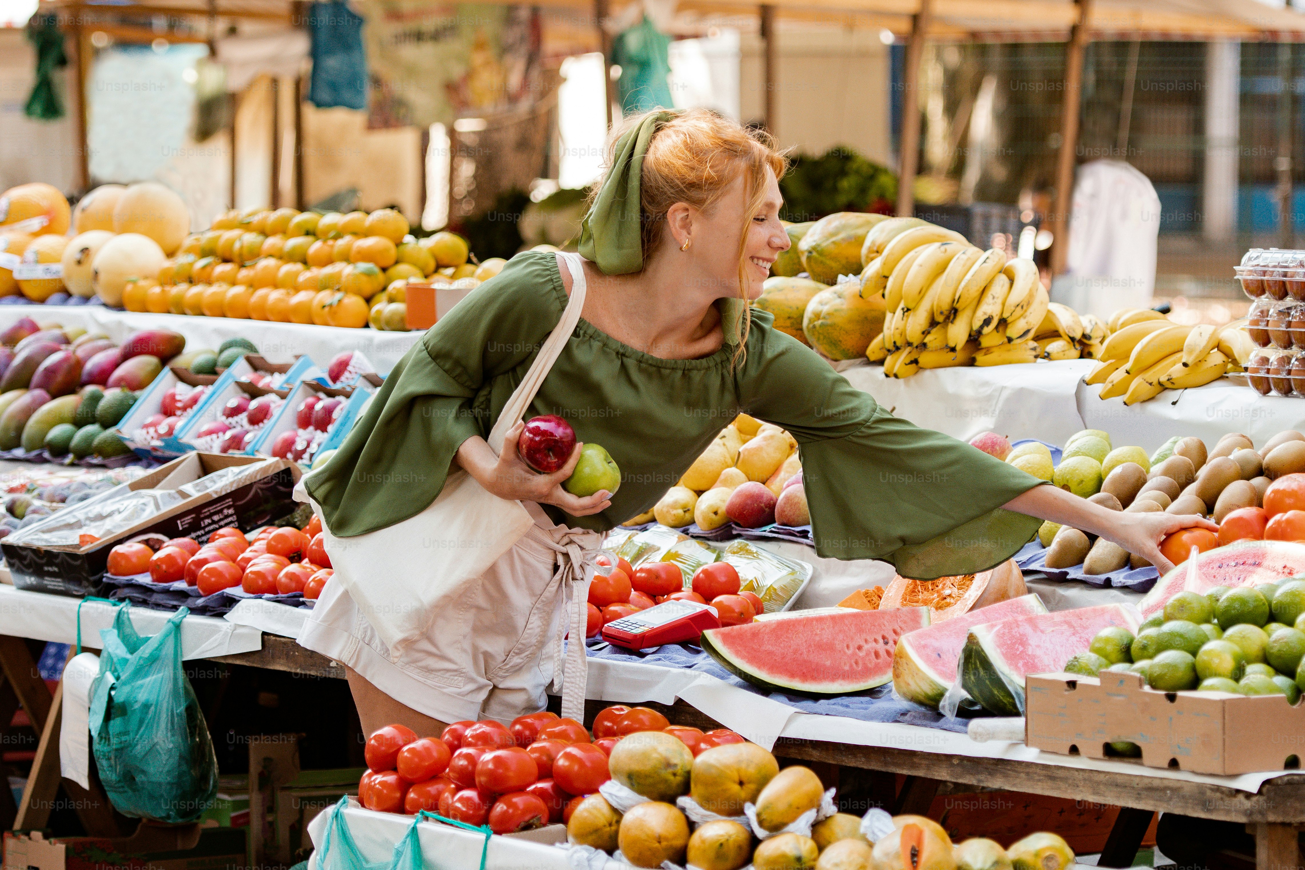 a woman standing in front of a fruit stand