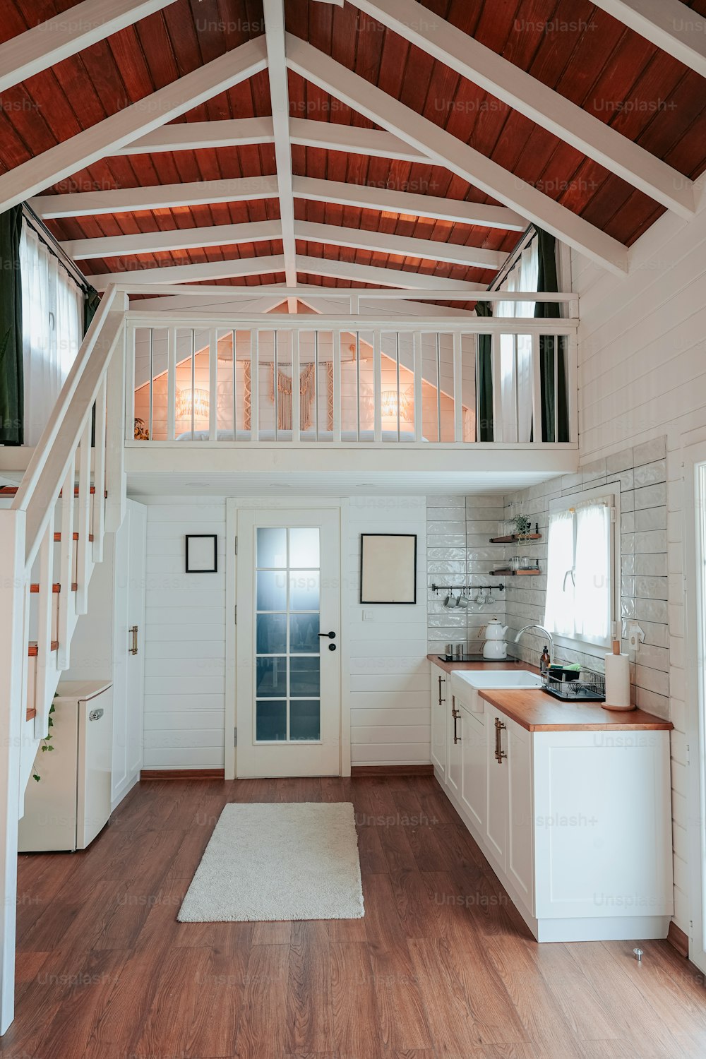a kitchen with a wooden floor and white walls