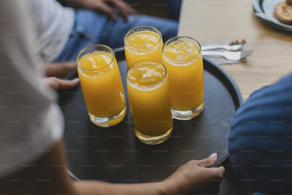 tres vasos de zumo de naranja en una bandeja