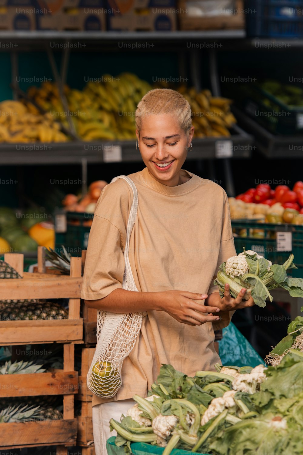 Una donna in piedi di fronte a un'esposizione di verdure