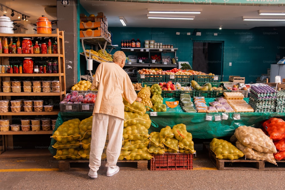 a man standing in front of a fruit stand