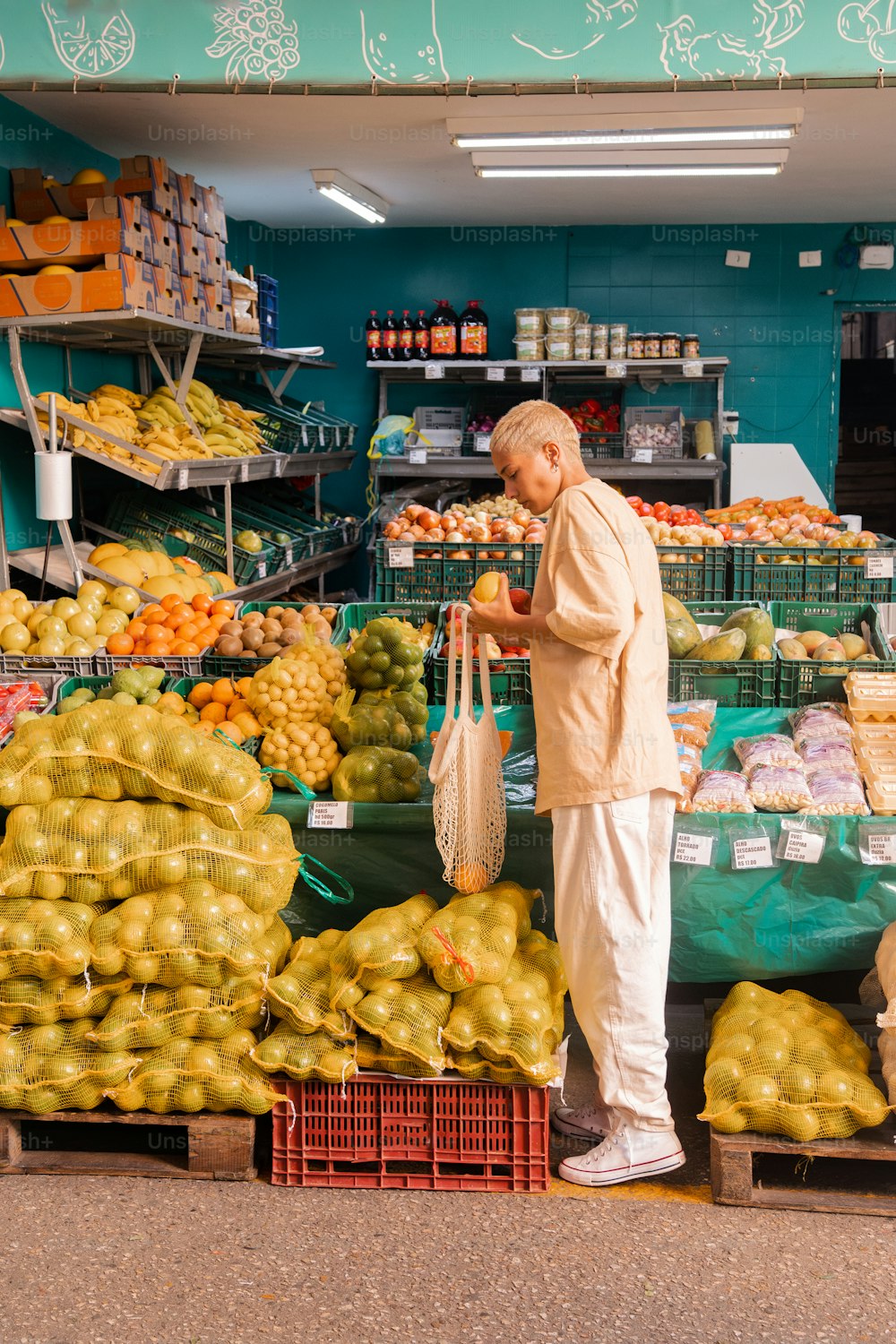 Un homme debout devant un stand de fruits