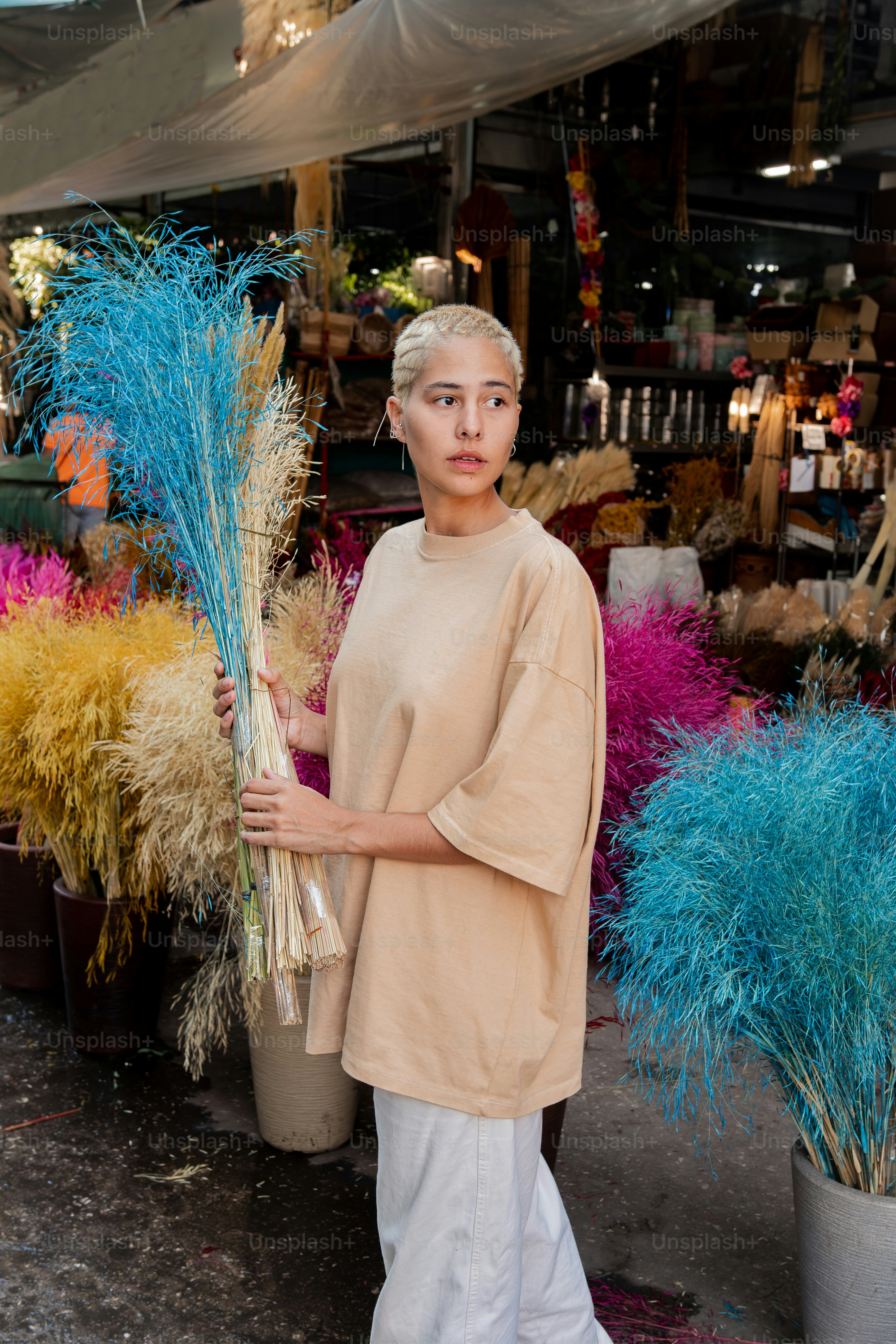 a woman standing in front of a bunch of plants