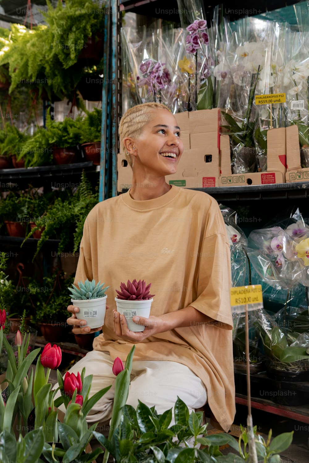 a woman sitting in a flower shop holding a potted plant