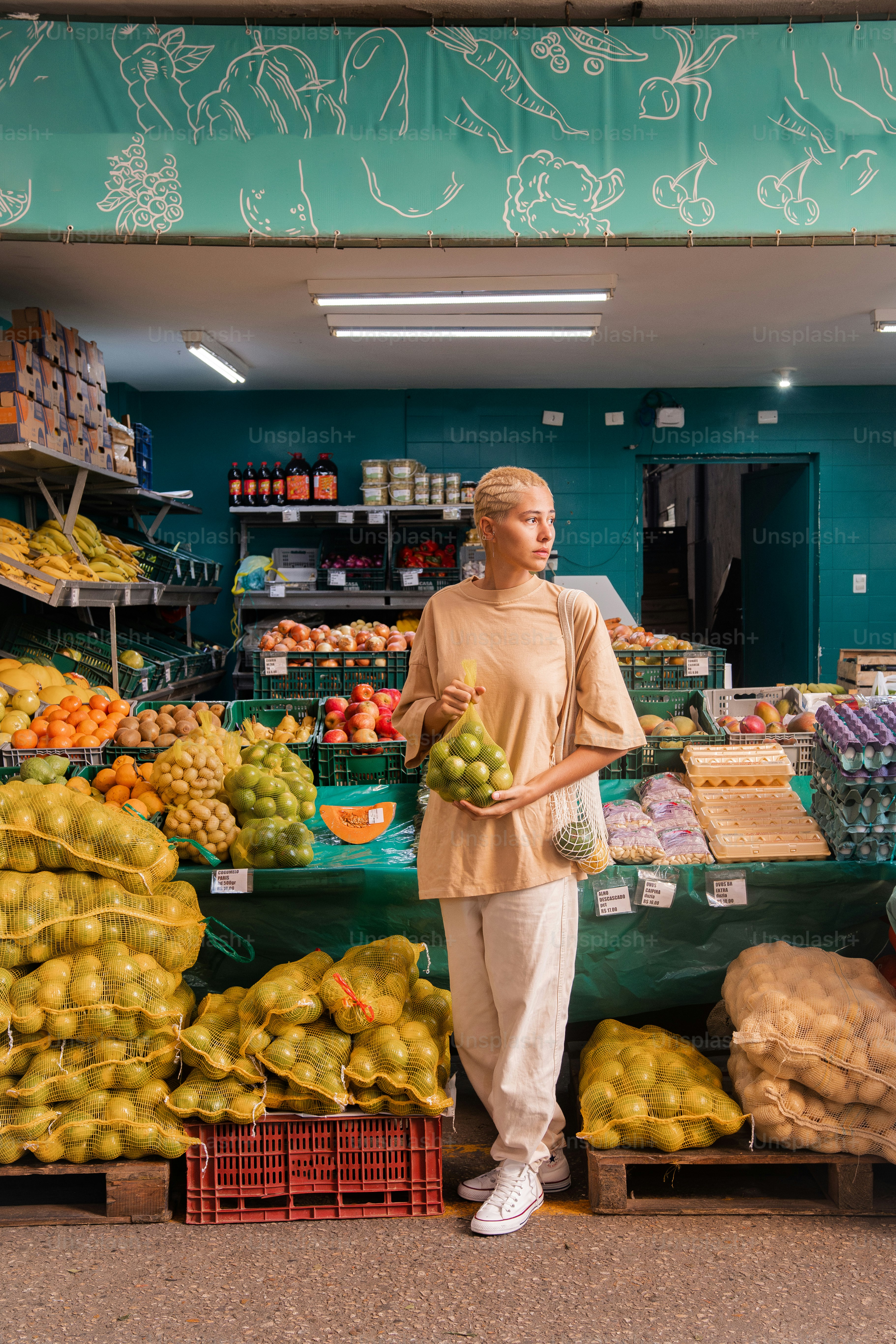 a woman standing in front of a fruit stand