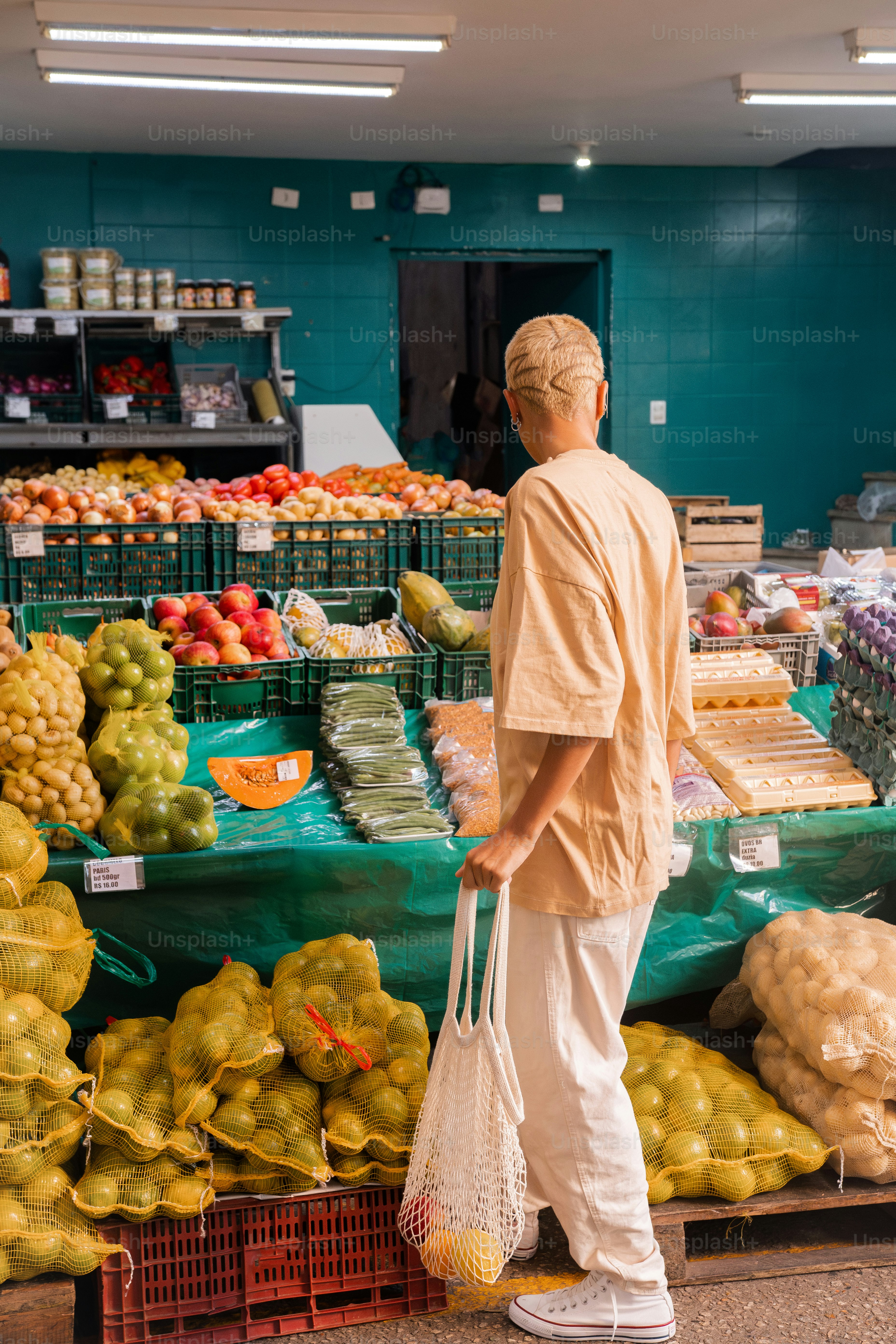 a man standing in front of a fruit stand