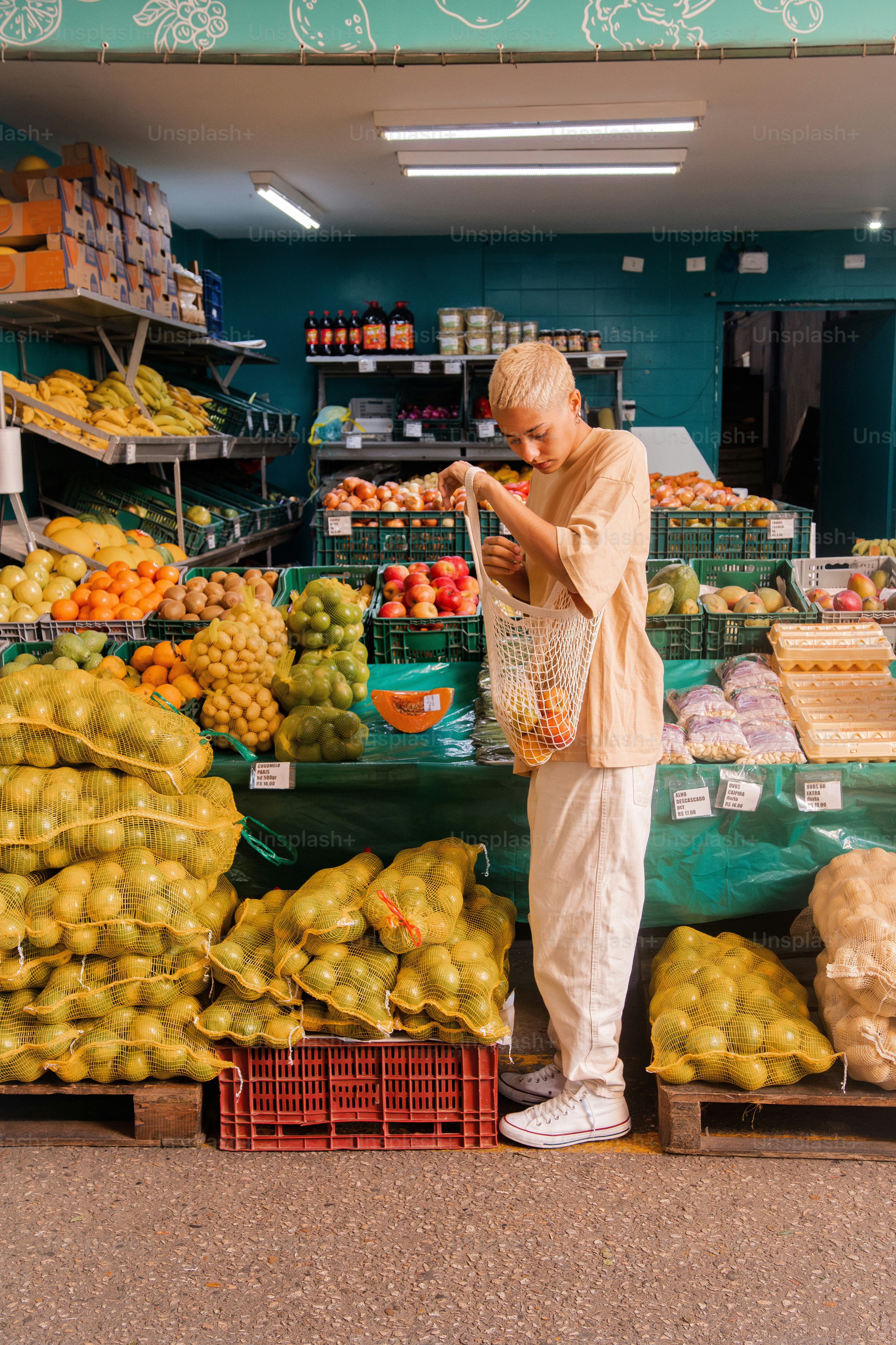 Un uomo in piedi di fronte a un banco di frutta