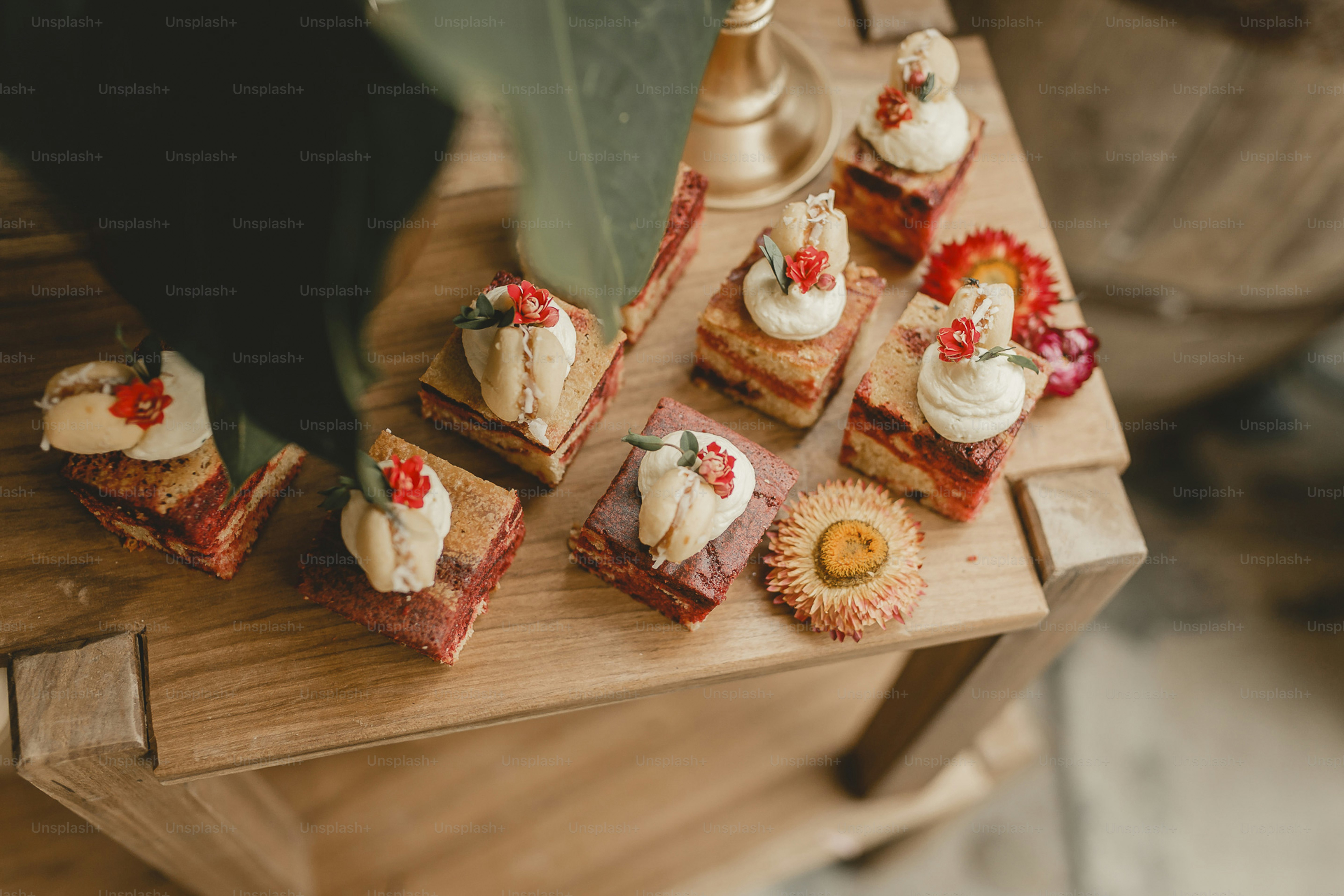 A wooden table topped with lots of small cakes photo – Food Image on ...