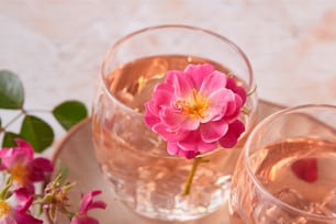 Una flor rosa sentada en un vaso de agua