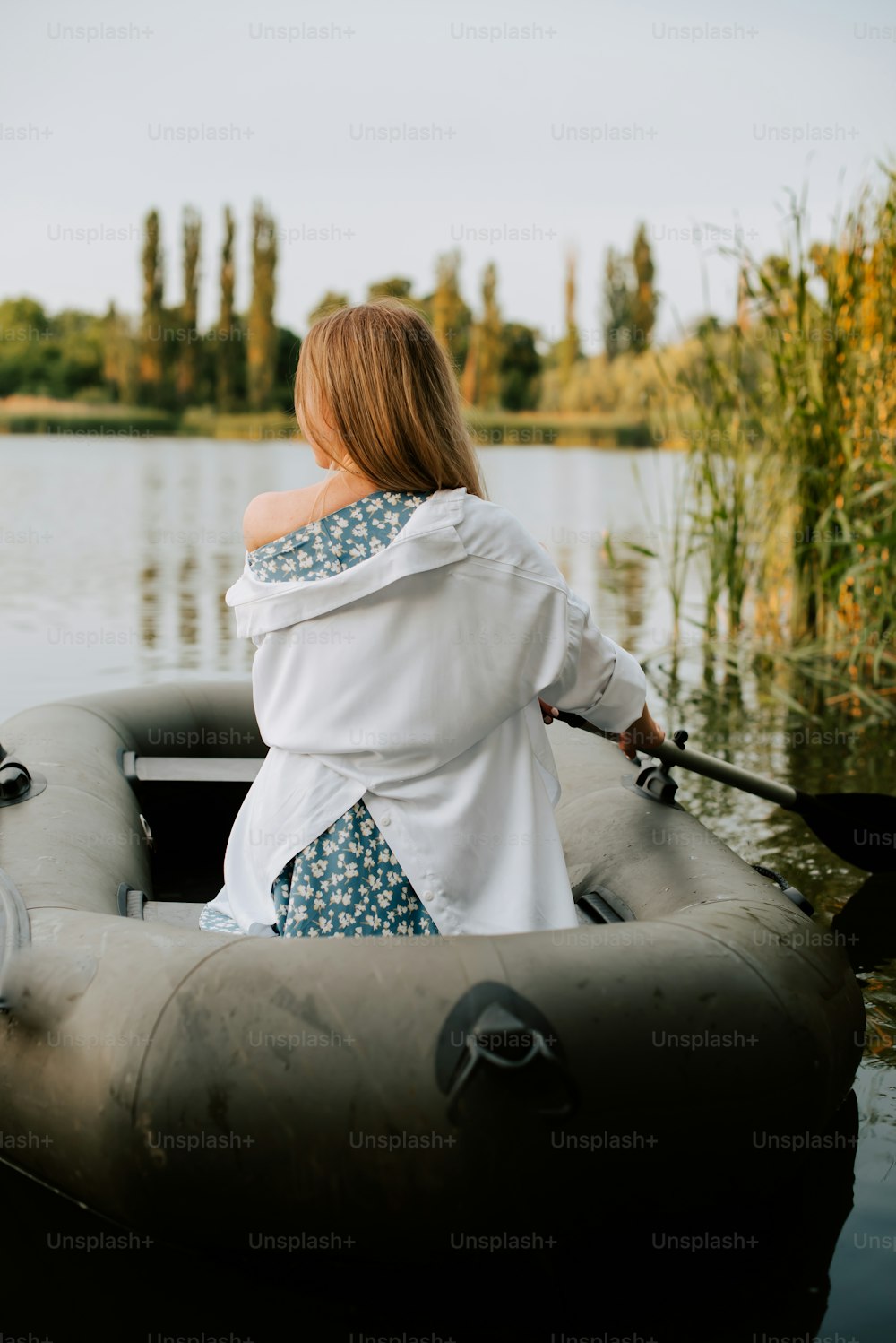 a woman sitting in a boat on a lake