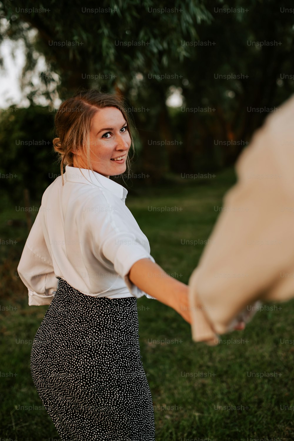 a woman in a white shirt and a black and white skirt