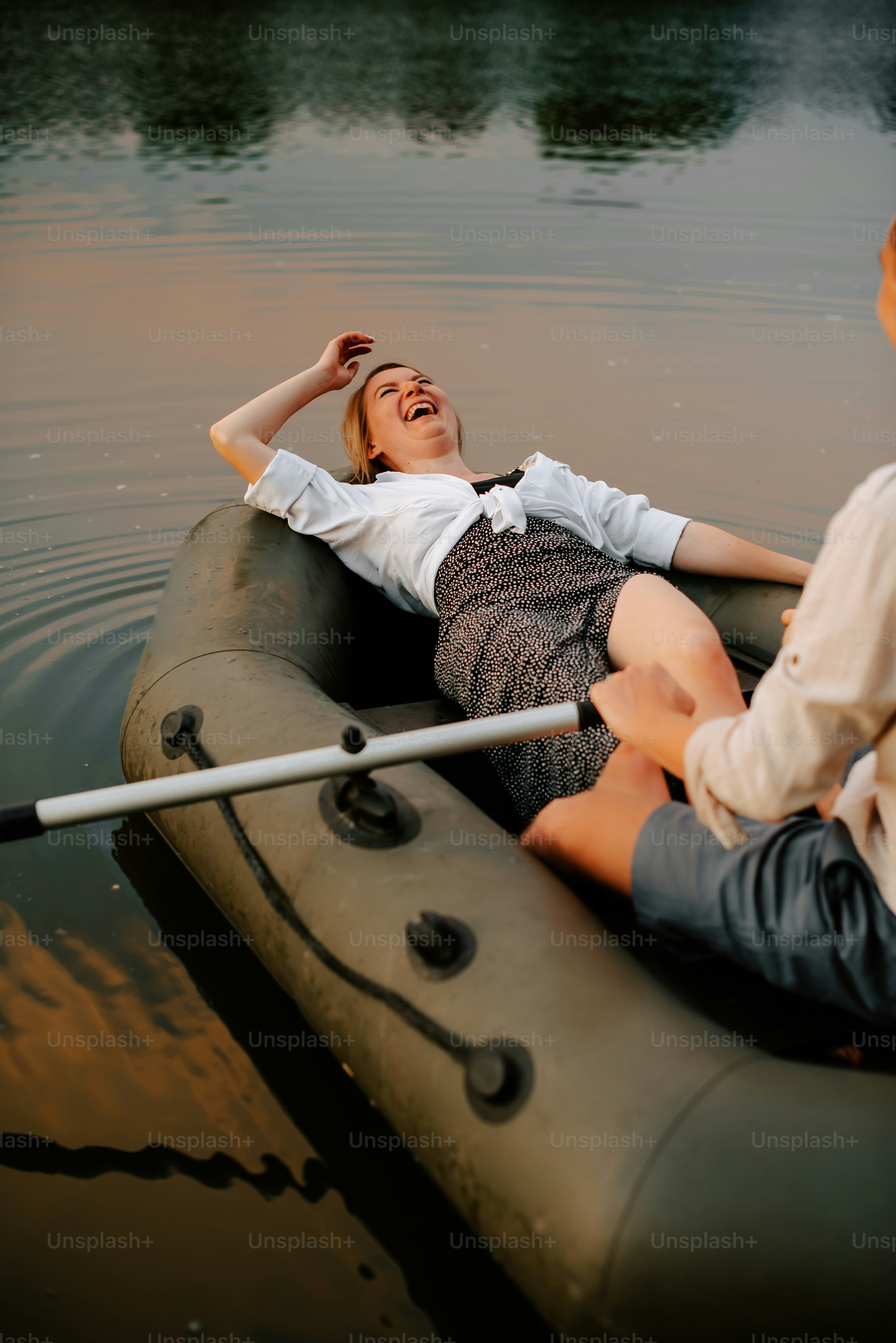 A woman laying on top of a raft in the water photo – Laughing Image on ...