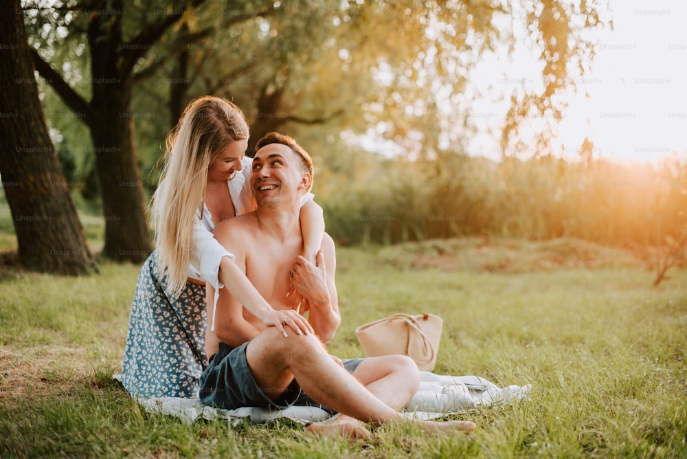 Ein Mann und eine Frau, die auf einer Decke im Gras sitzen
