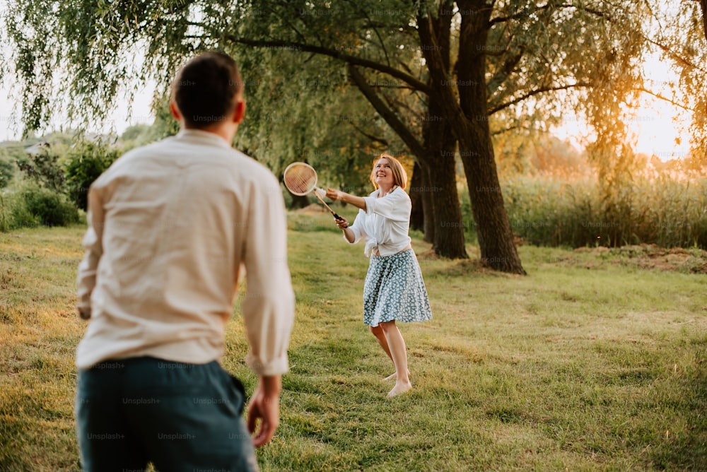 a man and a woman playing tennis in a field
