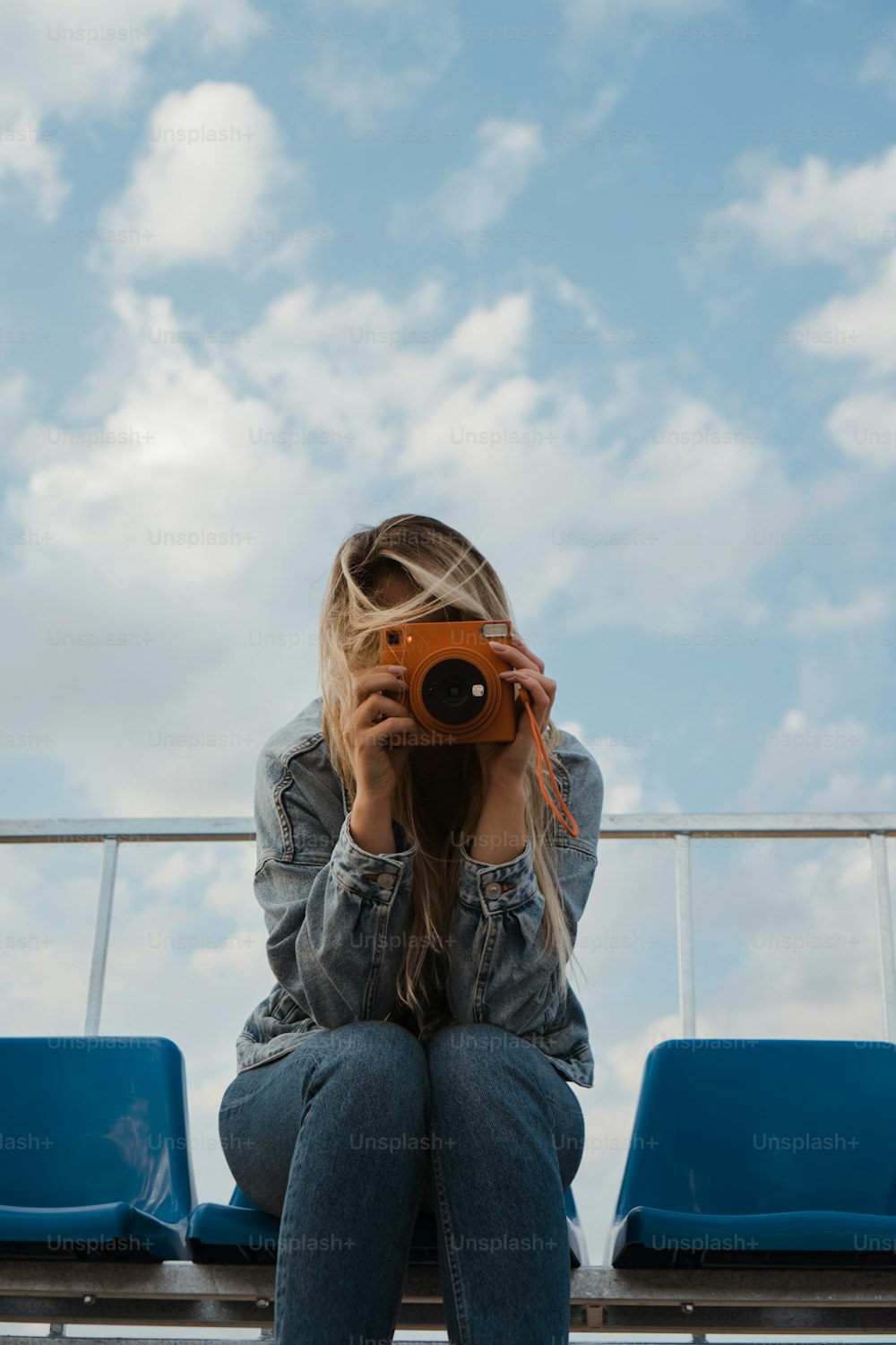 a woman sitting on a bench holding a camera