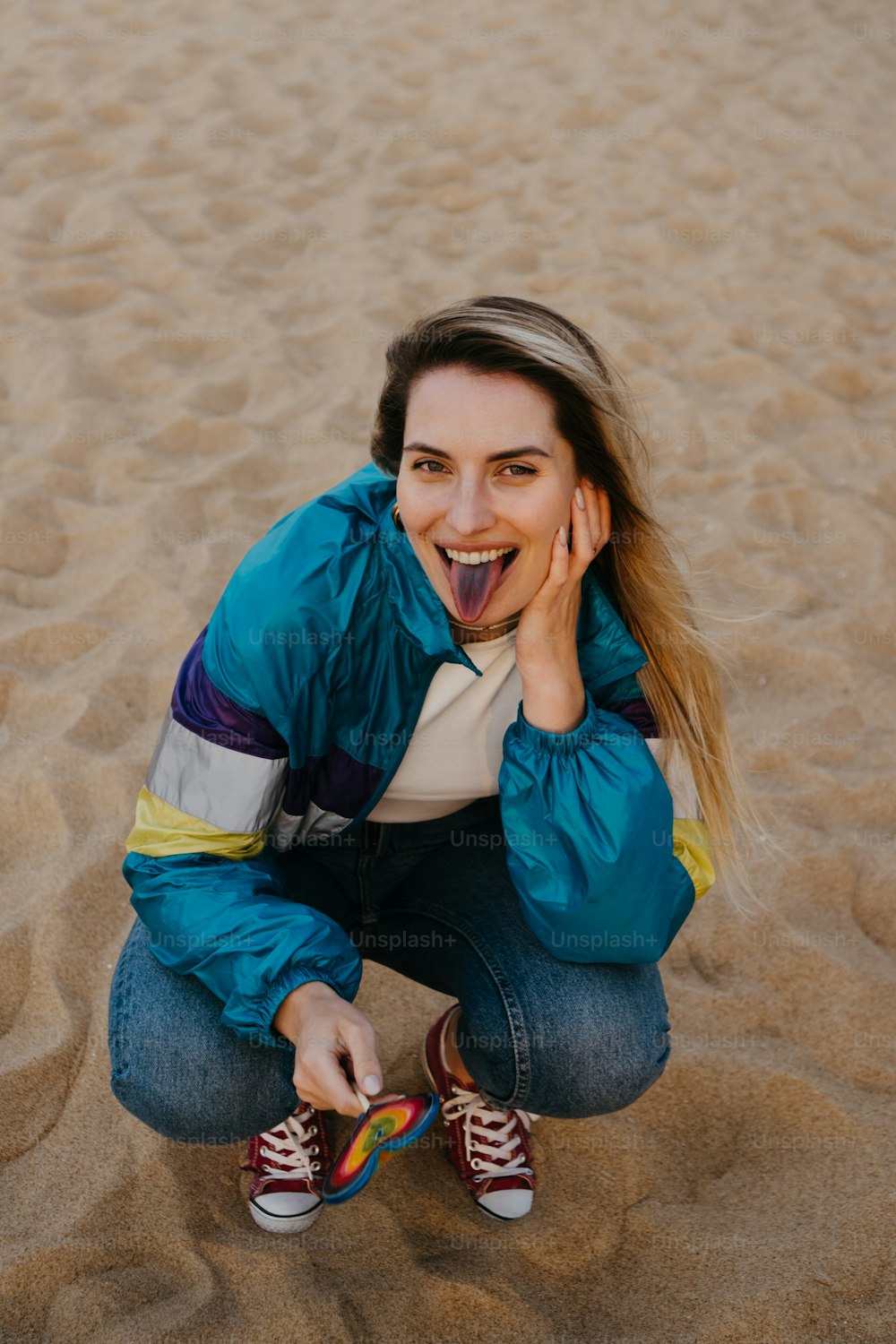 a woman sitting in the sand with her mouth open