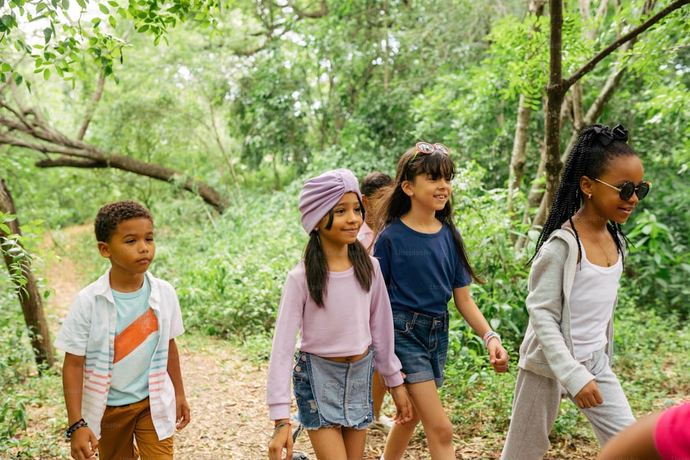 a group of young children walking through a forest