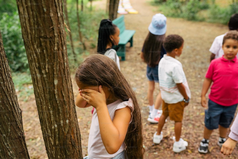a group of children standing next to each other in a forest