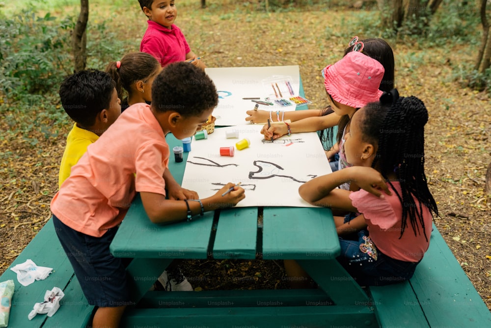 um grupo de crianças sentadas em uma mesa de piquenique