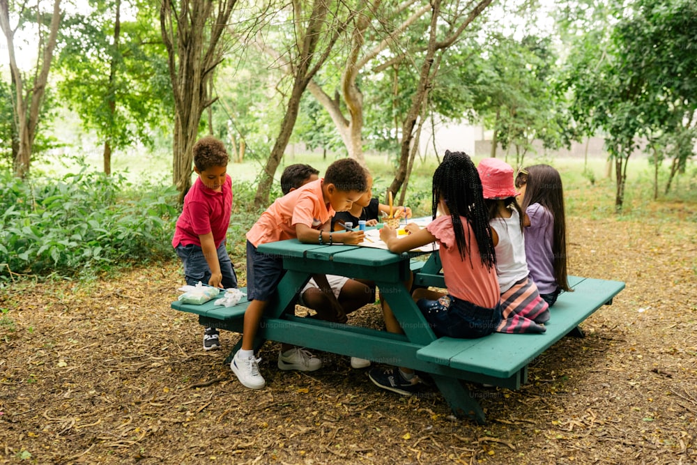 a group of kids sitting at a picnic table