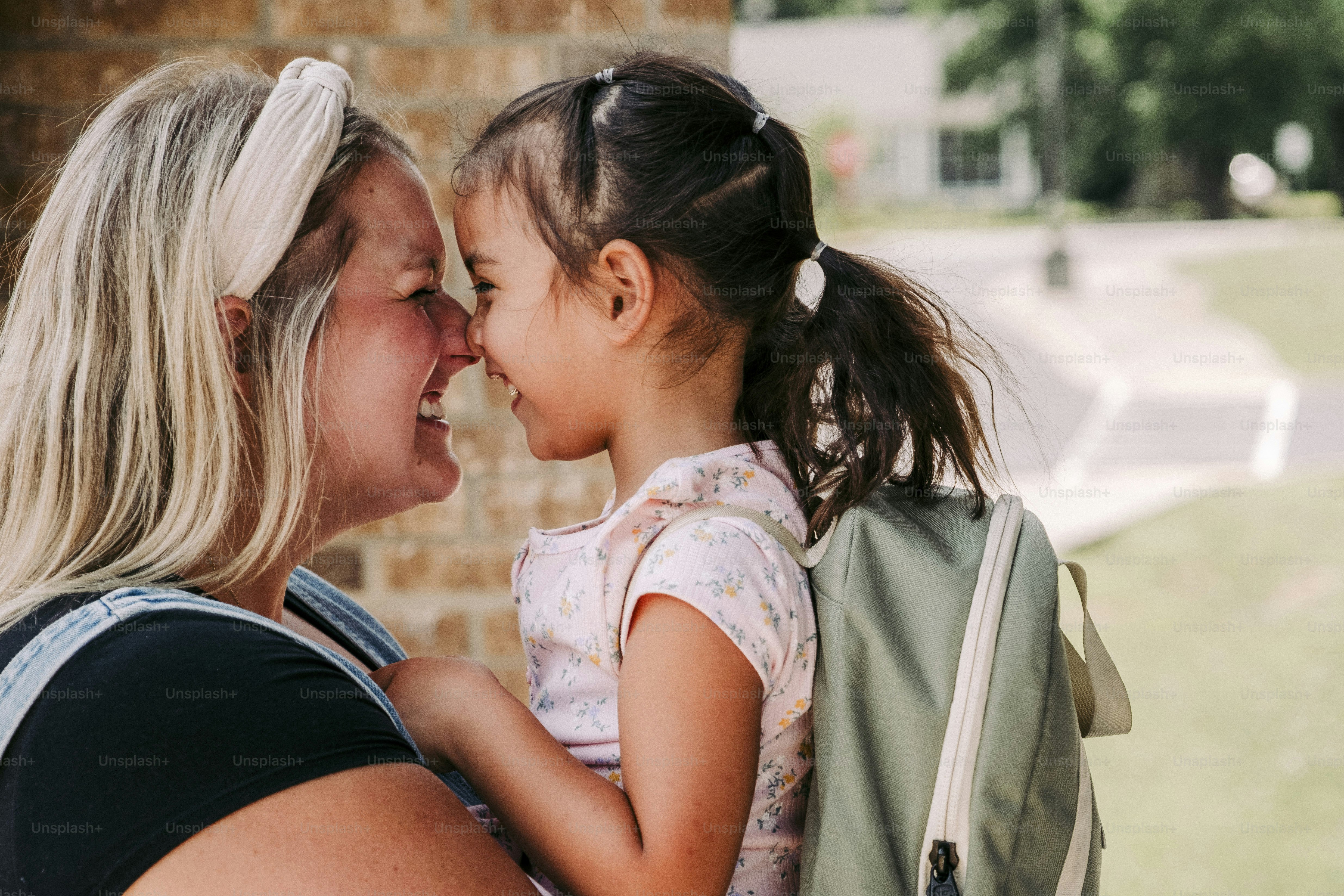 a woman holding a little girl in her arms