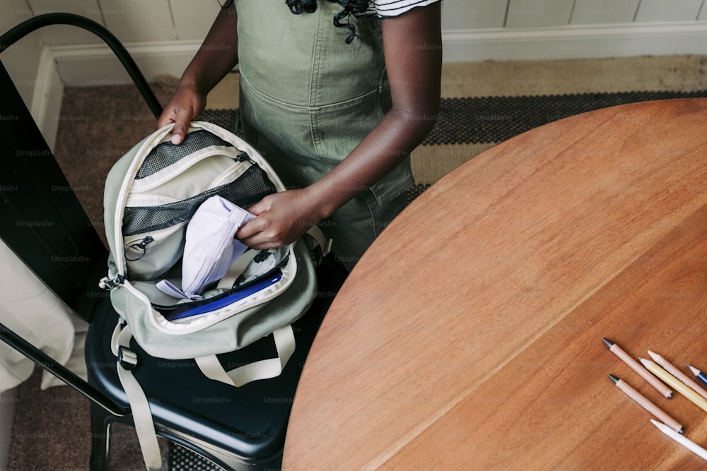 Una mujer de pie junto a una mesa de madera